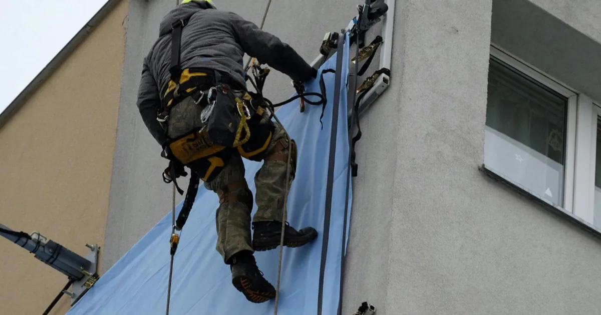 Grieta en la fachada de un edificio de Valencia inspeccionada por un albañil